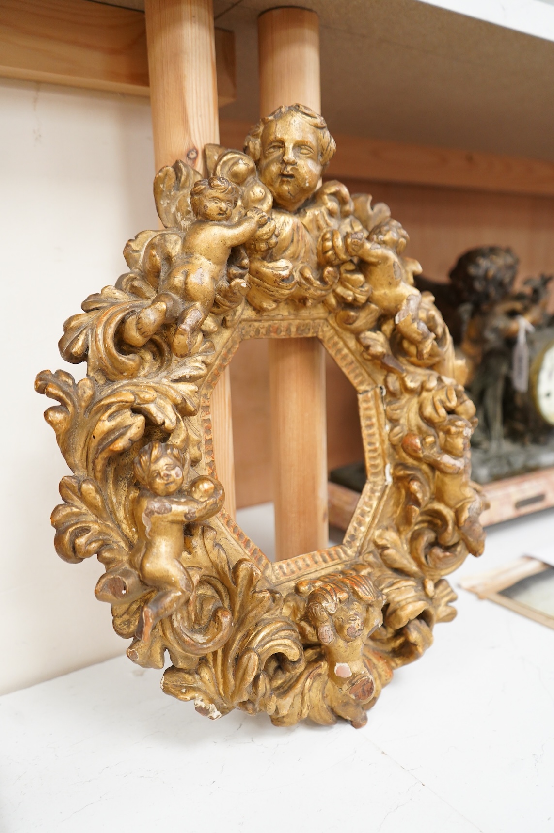 A late 17th/early 18th century Italian carved giltwood cherub frame with octagonal aperture, 37cm high